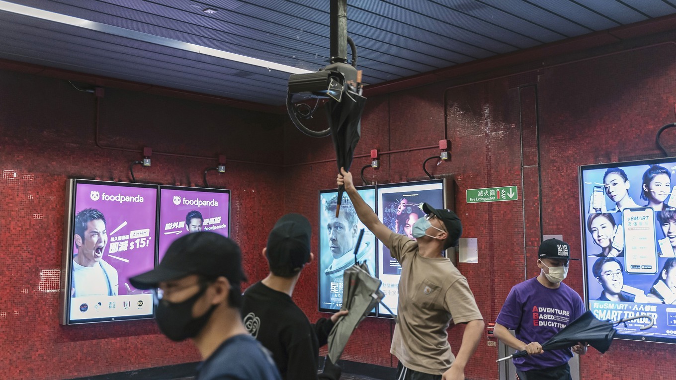 Demokratidemonstranter förstör en övervakningskamera på Tai Koo MTR-stationen i Hongkong. Foto: Anthony Kwan/Getty Images